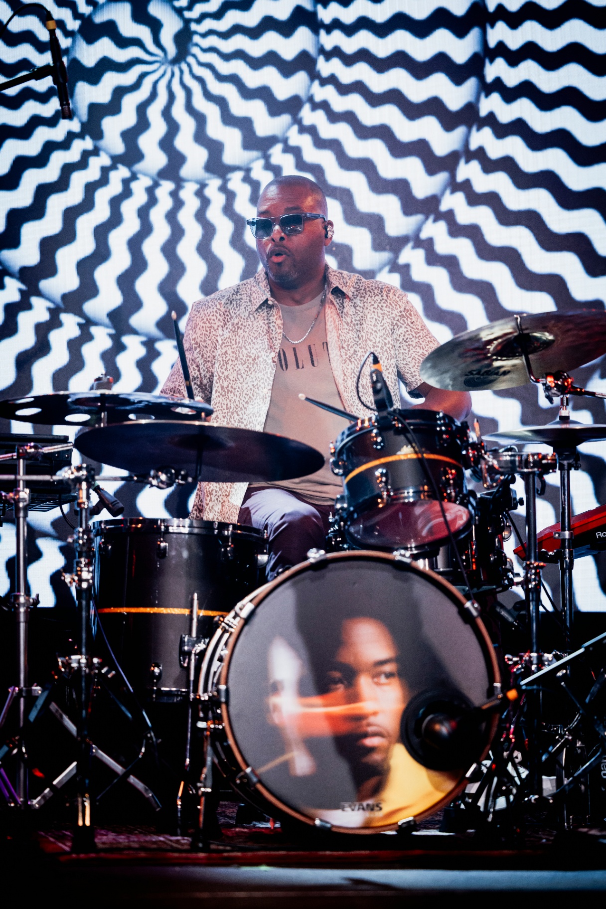 Keith on drums in front of a hypnotic black-and-white screen