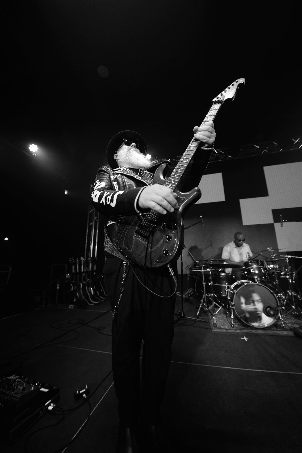 George playing guitar in a black-and-white stage portrait