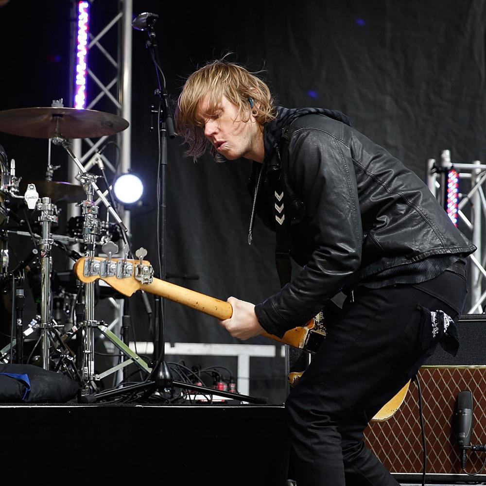 Bassist leaning into an amp at a festival