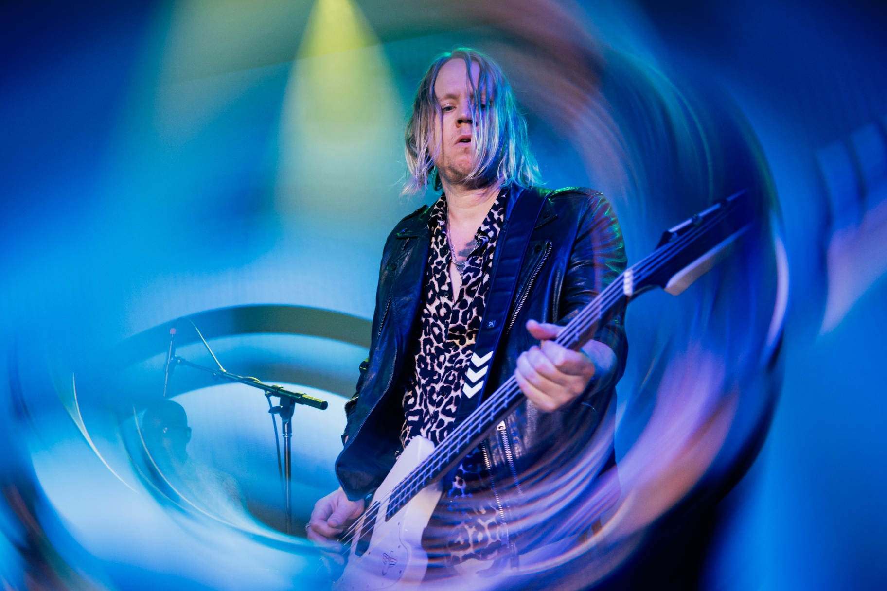 Bassist in blue stage lights with motion blur
