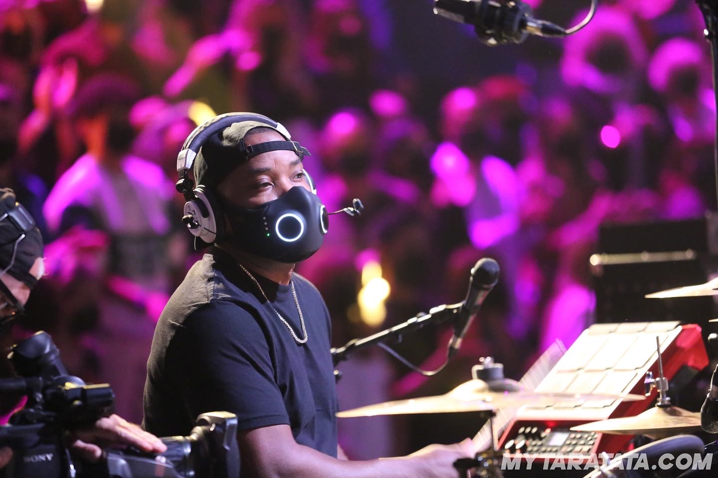 Drummer performing under stage lights